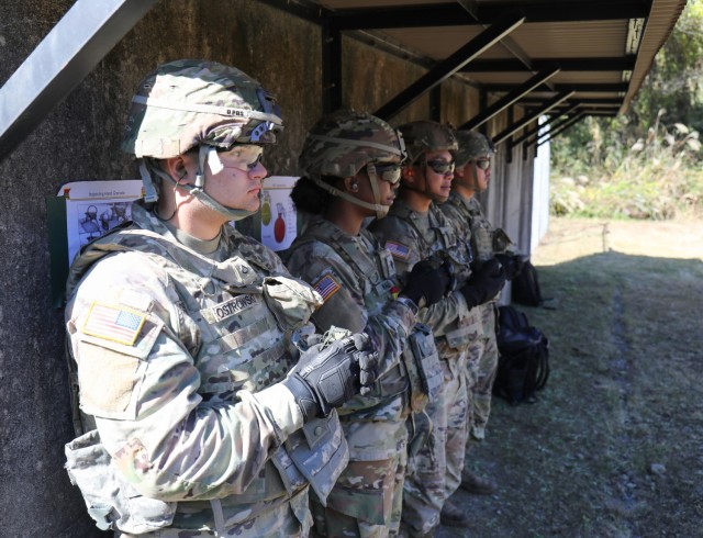 Four Soldiers assigned to the 35th Combat Sustainment Support Battalion hold onto hand grenades as they wait to enter a range at Combined Arms Training Center Camp Fuji, Japan, Nov. 2, 2022. About 30 Soldiers from the battalion threw grenades during a week of live-fire training that also included small arms and crew-served weapons to better prepare the unit for possible base defense missions. 