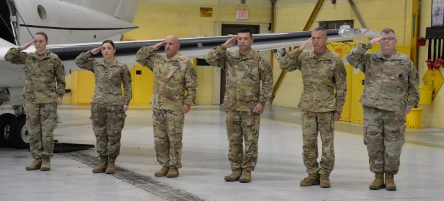 Six New York Army National Guard Soldiers assigned to Detachment 5 of Company C, 2nd Battalion, 245th Aviation Regiment salute during the playing of the Star-Spangled Banner at a deployment farewell ceremony at Army Aviation Support Facility # 3 in Latham, New York on November 6, 2022. The Soldiers, who fly the C-12 Huron transport aircraft, will deploy to Djibouti in East Africa to support United States military forces in the region.