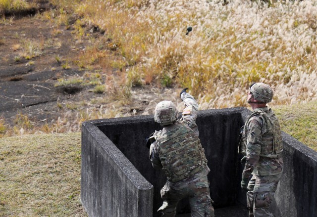 A Soldier assigned to the 35th Combat Sustainment Support Battalion throws a hand grenade into a small range at Combined Arms Training Center Camp Fuji, Japan, Nov. 2, 2022. About 30 Soldiers from the battalion threw grenades during a week of live-fire training that also included small arms and crew-served weapons to better prepare the unit for possible base defense missions. 