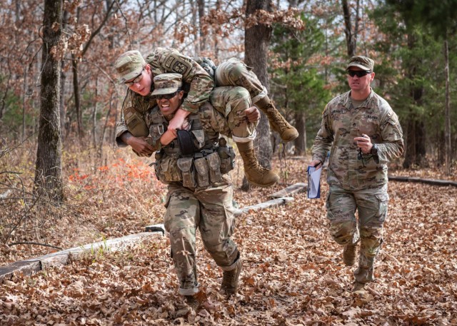 University of Iowa Cadet Trejahn Manning carries one of his nine-person division teammates, Cadet Joseph Junker, to the finish line of the Hand Grenade Assault Course Friday on Range 31 during the 3rd Brigade ROTC Ranger Challenge competition. The...