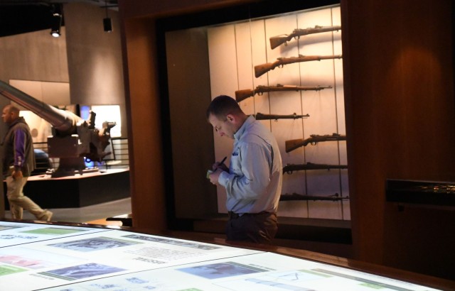 Knowledge Management Qualification Course student Maj. David Brooks takes notes while viewing the exhibits at the National WWI Museum and Memorial, Kansas City, Mo., Oct. 28, 2022. After viewing the museum, students gathered for a wraparound discussion of KM practices then and now. 