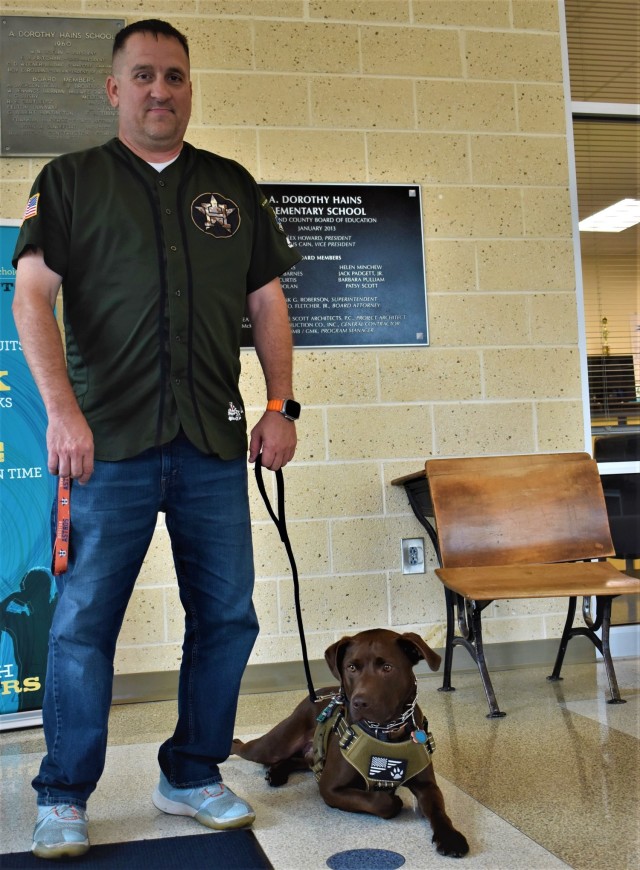 Retired Staff Sgt. Mark Villegas and his service dog, Astro, take a moment following a visit from Fort Gordon Soldiers. Villegas, a former military police officer who medically retired after about 13 years of service, has been teaching at A. Dorothy Hains Elementary School in Augusta, Georgia, for the past six years. 