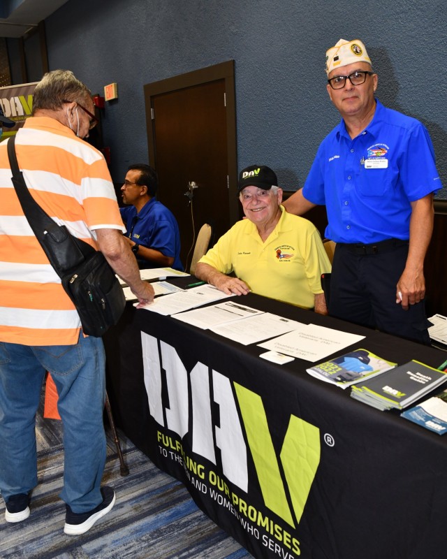 Disabled American Veterans (DAV) had three tables assisting Retirees, Veterans and their families. (L to R) Carlos Plansenti a DAV Chapter member and DAV Department of PR Commander Delvis Collazo Rivera assist a Retiree with an application.