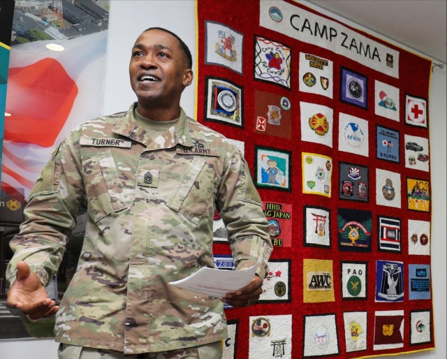 Command Sgt. Maj. Justin E. Turner, senior enlisted leader of U.S. Army Garrison Japan, speaks during a ceremony to unveil a community quilt at Camp Zama, Japan, Nov. 1, 2022. Turner recently spoke about his time in Japan before he relinquishes his responsibility to Command Sgt. Maj. David Rio during a ceremony Dec. 2, 2022. 