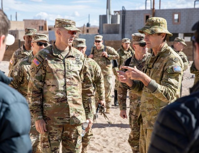 U.S. Army Gen. Randy George (left) vice chief of staff of the Army, and Australian Lt. Col. Stuart Purves, liaison at Army Futures Command, discuss an experiment during Project Convergence 2022 on Nov. 3, 2022 at Fort Irwin, Calif. Project Convergence is an all-service and multinational effort to test and integrate emerging technologies.