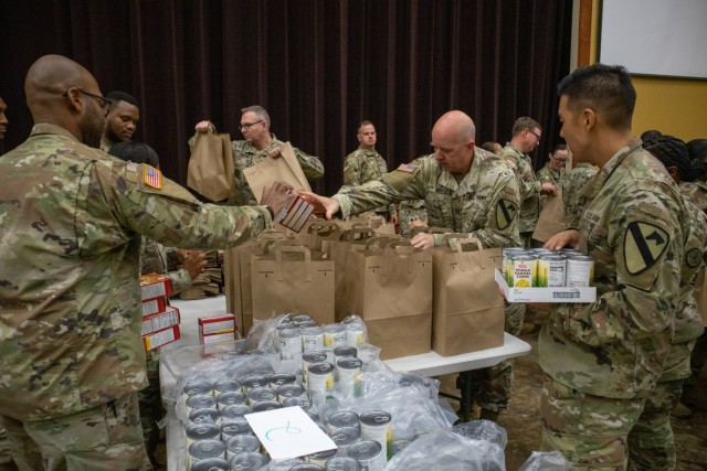 Soldiers, veterans, and volunteers distribute Thanksgiving care packages to families in need