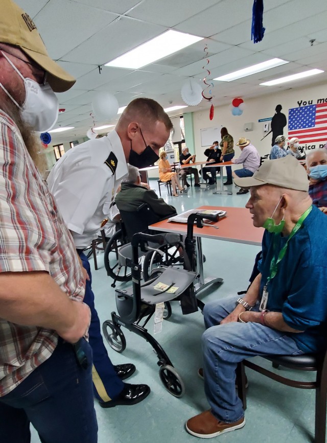 Fort Buchanan Religious Support Volunteer, US Air Force (Ret.) Joseph Bender and Garrison Command Chaplain Maj. David S. Keller converse with a Veteran, sharing their experiences.