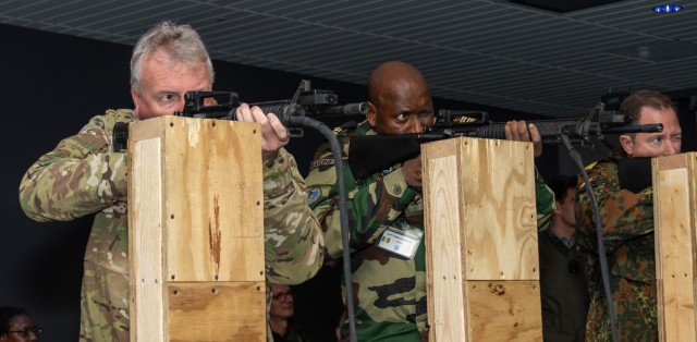 Defense attachés Brig. Gen. Michael Shapland of New Zealand, Capt. Malick Ndiaye of Senegal, and Rear Adm. Axel Ristau of Germany fire at targets on a range simulator at Fort Indiantown Gap’s Training Support Center Nov. 16, 2022, during the Defense Intelligence Agency’s Fall 2022 Operations Orientation Program tour of Pennsylvania National Guard facilities. (Pennsylvania National Guard photo by Wayne V. Hall)