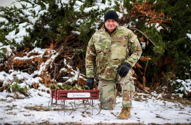 Sgt. 1st Class Michael Sullivan, assistant operations noncommissioned officer with the 734th Regional Support Group, Iowa Army National Guard, kneels next to “Sully’s Lil Red Wagon” at Camp Dodge in Johnston, Iowa, Nov. 17, 2022. Sullivan...