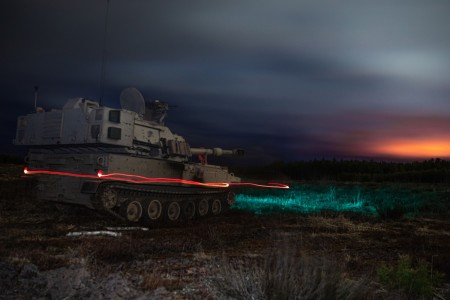 An M109A7 Self-Propelled Howitzer assigned to the 1st Battalion, 5th Field Artillery Regiment, 1st Armored Brigade Combat Team, 1st Infantry Division, drives off after lighting the night sky with an illumination round during Baltic Ballista, a multinational exercise held at Pabrade Training Area, Lithuania, April 21, 2022. As part of the event, the Soldiers conducted training and platoon certifications on Artillery Table XII.