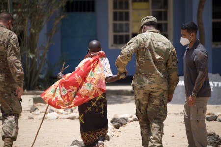 Soldiers assist a Kenyan village elder seeking care during Exercise Justified Accord in Isiolo, Kenya, March 15, 2022. More than 800 personnel participated in Justified Accord, which included multinational field training and a command post exercise.