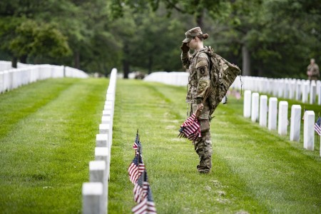 A Soldier salutes while helping to place U.S. flags at every gravesite at Arlington National Cemetery, Va., during Flags In, May 26, 2022. The pre-Memorial Day tradition to honor the nation’s fallen heroes dates to 1948.