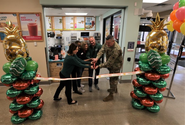 Fort Knox Garrison Command Sgt. Maj. William Fogle (right) alongside Chief of Nutrition Care Services at Ireland Army Health Clinic Laura Bottoms (left) and representatives from the Exchange and Tropical Smoothie Café cut the ribbon Dec. 1, 2022...