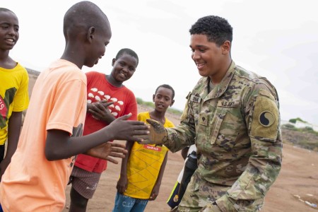 Army Spc. Tristan Znati plays with children during a tree-planting event in Damerjog, Djibouti, Jan. 7, 2022.