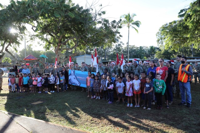 U.S. Army Soldiers from the 3rd Squadron, 4th Cavalry Regiment, 3rd Infantry Brigade Combat Team, 25th Infantry Division pose for a photo with the children at Ka’Ala Elementary School in Wahiawa, HI, Dec. 1, 2022. The soldiers completed a ruck march to Ka’Ala Elementary School to deliver donated gifts in hopes of supporting the school and children during the holiday season. (U.S. Army photo by Sgt. Katelyn Vazquez/28th Public Affairs Detachment)