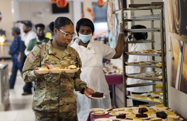 A trainee with Company B, 3rd Battalion, 34th Infantry Regiment, reaches for a slice of chocolate cake to go with her Thanksgiving meal. Trainees were served their Thanksgiving meal by their drill sergeants. The trainees were able to eat ham,...