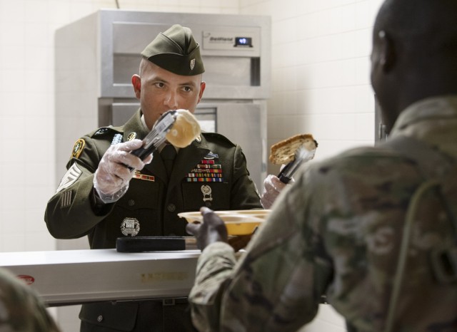 First Sgt. Christopher Picache, from Company B. 3rd Battalion, 34th Infantry Regiment, asks if a trainee wants a biscuit or a slice of bread with his Thanksgiving meal, Nov. 23 Leaders began serving their Soldiers Thanksgiving meals early on Fort Jackson. The troops were served a traditional meal with all the fixings.