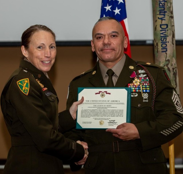 1st Infantry Division Deputy Commanding General-Support, U.S. Army Brig. Gen. Niave F. Knell, presents U.S. Army Command Sgt. Maj. Albert Serrano, the outgoing ready reserve command sergeant major for 1st Inf. Div., the Legion Of Merit award for exceptional service throughout his 30-year career. The Legion of Merit award is presented only to those of exceptional service who served as a prime example of the army values and standards. (U.S. Army Photo by Pfc. Kenneth Barnet)