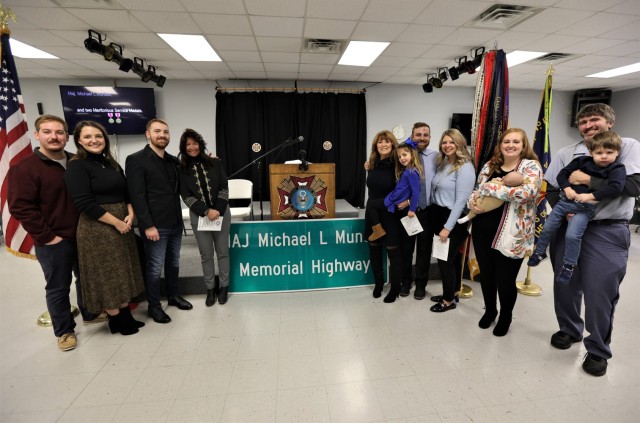 Gold Star Family members of fallen Soldier Maj. Michael Mundell stand with a replica sign at the Dec. 10, 2022 dedication ceremony representing the one motorists will now see on a portion of state Highway 1638 in Meade County.