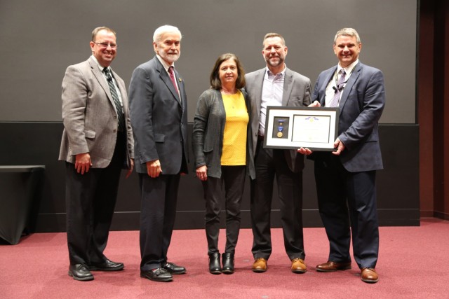 Outgoing S3I Principal Deputy Stan Sherrod is recognized during his last S3I town hall. From left is Dr. James Kirsch, S3I director, Joe Fitzgerald, CASA; Jennifer Sherrod, Sherrod&#39;s spouse; Sherrod; and Jeff Langhout, DEVCOM AvMC director.