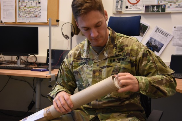 Maj. Joseph Davis, JFTC Media Division, opens a package during Exercise Loyal Leda 2022 in Bydgoszcz, Poland. The 10-day combat readiness evaluation exercise hosted at the NATO Joint Force Training Centre was an Allied Land Command-sponsored, land domain, tactical level, virtual command post exercise held from Nov. 30 to Dec. 9.