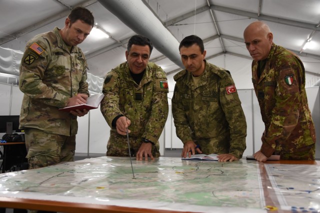 Sgt. 1st Class Aaron Welch, NRDC-Spain G3, and three other members of the current operations team from Portugal, Turkiye and Italy review ongoing operations during Exercise Loyal Leda 2022 in Bydgoszcz, Poland. The 10-day combat readiness evaluation exercise hosted at the NATO Joint Force Training Centre was an Allied Land Command-sponsored, land domain, tactical level, virtual command post exercise held from Nov. 30 to Dec. 9.
