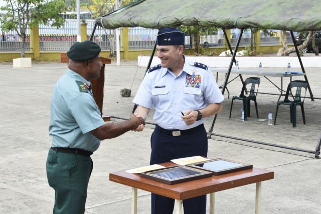 Maj. Gen. Paul Knapp, Wisconsin’s adjutant general, and Maj. Gen. Mark Goina, chief of the Papua New Guinea Defence Force, shake hands after signing a State Partnership Program agreement Dec. 2, 2022, in Port Moresby, Papua New Guinea. (Wisconsin National Guard photo by Maj. Brian Faltinson)
