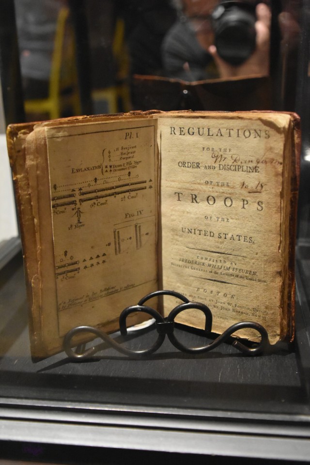 A copy of the U.S. Army’s first set of regulations, commonly called the “Blue Book,” is displayed Dec. 3, 2022, at the Department of the Army Inspector General celebration of the IG system’s 245th birthday in Arlington, Virginia. Maj. Gen. (Baron) Friederich Wilhelm von Steuben, a former Prussian officer, was the first effective Army inspector general, and he wrote the “Blue Book.” (U.S. Army photo by Thomas Ruyle)
