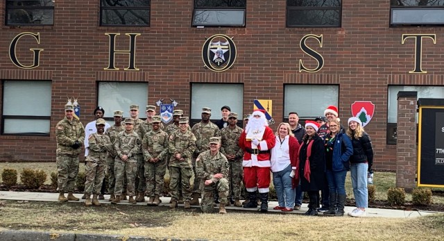 1st Brigade, 2nd Infantry Division soldiers and volunteers pose with Santa Claus after receiving their gift cards, courtesy of the United States Army’s Captain Meriweather Lewis Chapter and their community partners.
