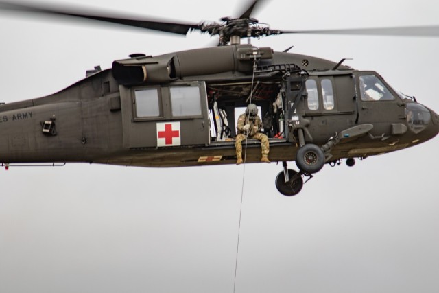 A UH-60L Black Hawk helicopter assigned to U.S. Army Air Ambulance Detachment-Yakima, 16th Combat Aviation Brigade, hoists a crew member at Yakima Training Center, Wash. on Dec. 7, 2021. The unit regularly conducts live hoist training flights to maintain proficiency for military and civil aeromedical evacuation missions. (U.S. Army photo by Capt. Kyle Abraham, 16th Combat Aviation Brigade)