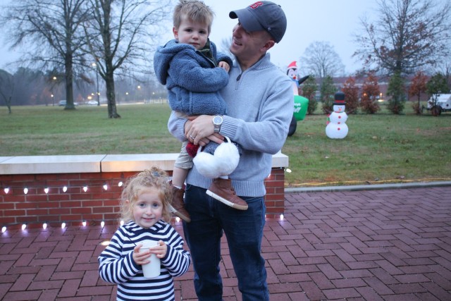 Capt. Edward Bentz, medical operations officer, 1st Theater Sustainment Command celebrates the start of the holiday season with his children at the unit's tree lighting event, Dec. 9, 2022, at Fort Knox, Kentucky.