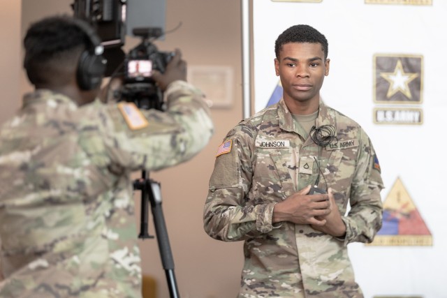 Pfc. Trevares Johnson, a 24th Theater Public Affairs Support Element Soldier, helps his camera operator set up an interview shot at Iron Summit, a two-day conference hosted by the 1st AD, at the El Paso Convention Center in El Paso, Texas, Dec. 13, 2022. Iron Summit brought leaders from Fort Bliss together to develop leader proficiency. Keynote speakers shared their expertise and lessons learned on organizational leadership, building cohesive teams, and caring for people.