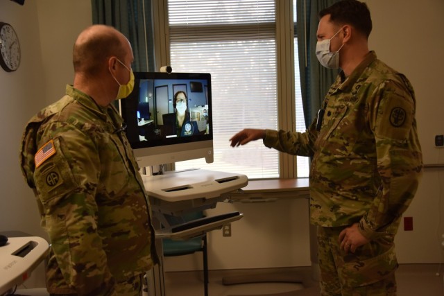 Col. (Dr) David De Blasio, deputy commander for medical services and Lt. Col. (Dr.) David Hostler, chief of pulmonary and critical care medicine at Womack Army Medical Center demonstrates how tele-critical care works. At the push of button Julia Powell, a nurse specialist assigned to San Diego, Joint Tele-Critical Care Network (JTCCN) responds ready to provide critical-care support, Dec. 2, 2022.