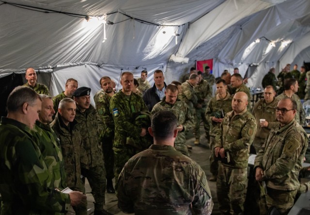 U.S. Army Maj. James McCarthy, a joint air ground integration cell chief assigned to the 1st Infantry Division (1 ID), briefs armed forces officers from Estonia, Finland, Lithuania, Poland and Sweden during Winter Strike 22, a command post exercise held in Bolesławiec, Poland, Dec. 12, 2022. The 1 ID is working alongside NATO allies and regional security partners to provide combat-credible forces to V Corps, America’s forward deployed corps in Europe.