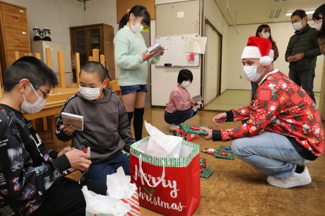 First Sgt. Stephen Graves, right, a member of the U.S. Army Japan Sergeant Audie Murphy Club, hands out gifts while visiting the Seikou Gakuen children&#39;s home in Zama, Japan, Dec. 21, 2022. Soldiers donated gifts from the Camp Zama community to children at the home as part of an outreach effort.