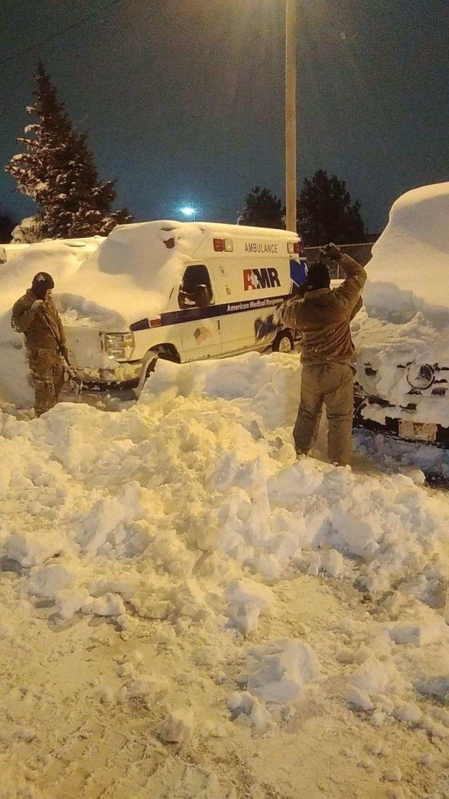 New York Army National Guard Soldiers assigned to the 827th Engineer Company and Airman assigned to the 174th Attack Wing help to clear snow to recover an AMR ambulance in Buffalo, N.Y. December 26, 2022, as part of the New York National Guard response to a major snowstorm. The New York National Guard deployed 433 Soldiers to western New York following the snow storm which hit the region over the Christmas weekend.