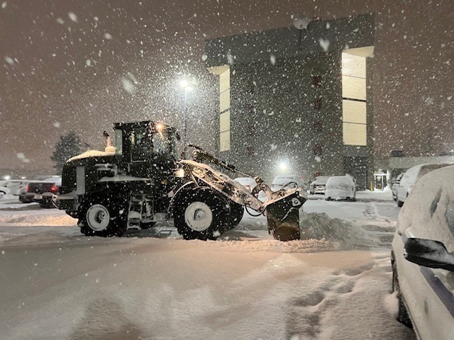 A New York Army National Guard Soldier assigned to the 827th Engineer Company uses a front end loader to clear snow from the parking lot at the Erie County Fire Training Academy in Cheektowaga, New York on Dec,. 26, 2022 in order to prepare a staging area for  local, country, and state first responders dealing with the snow storm. The New York National Guard mobilized 400 Airmen and Soldiers to respond to the storm.