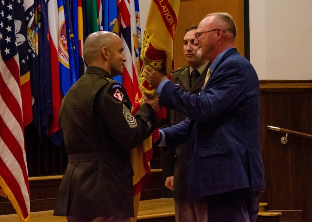 Command Sgt. Maj. Danny Castleberry, incoming U.S. Army Garrison Fort Leonard Wood command sergeant major (left), accepts the U.S. Army Installation Management Command guidon from Walter Mattil, deputy garrison commander, as Command Sgt. Maj. Sean...
