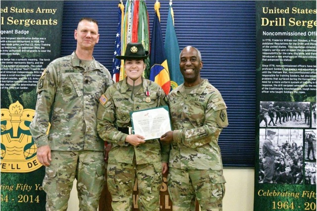 Active-duty Drill Sergeant of the Year Krista Osborne, with Company B, 2nd Battalion, 10th Infantry Regiment, is presented the Meritorious Service Medal after receiving the Drill Sergeant Belt Sept. 15 at the U.S. Army Drill Sergeant Academy, Fort...