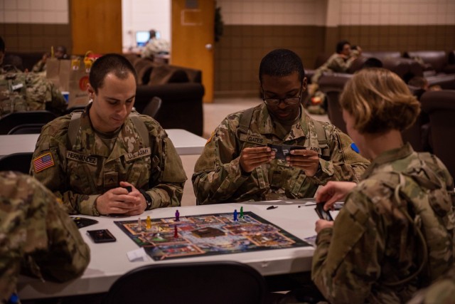 Pfc. David Gates (center) and Pvt. Esteban Hernandez, trainees with Company A, 3rd Battalion, 10th Infantry Regiment, play a board game with fellow trainees Dec. 29 at the USO during Holiday Block Leave. More than 200 Soldiers in training chose to stay at Fort Leonard Wood over the holidays. 