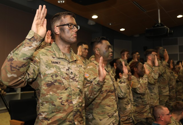 Twenty noncommissioned officers raise their right hand and recite an oath during an NCO induction ceremony at Sagami General Depot, Japan, Jan. 11, 2023. 