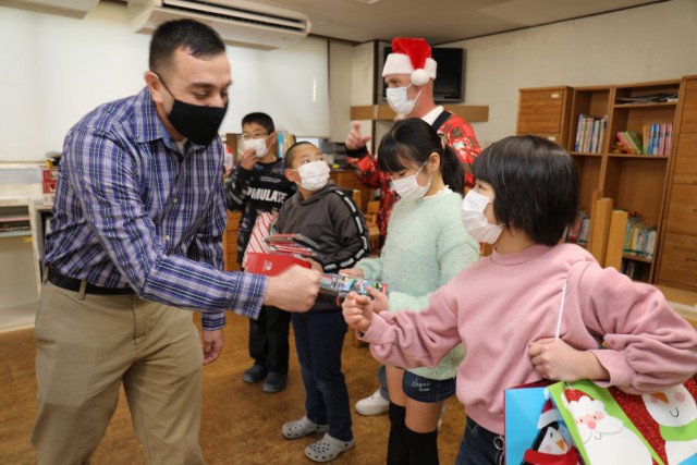 Command Sgt. Maj. David A. Rio, left, greets children while visiting the Seikou Gakuen children&#39;s home in Zama, Japan, Dec. 21, 2022. Rio, senior enlisted leader of U.S. Army Garrison Japan, joined other Soldiers to donate toys to the home during one of Camp Zama community&#39;s outreach efforts. 
