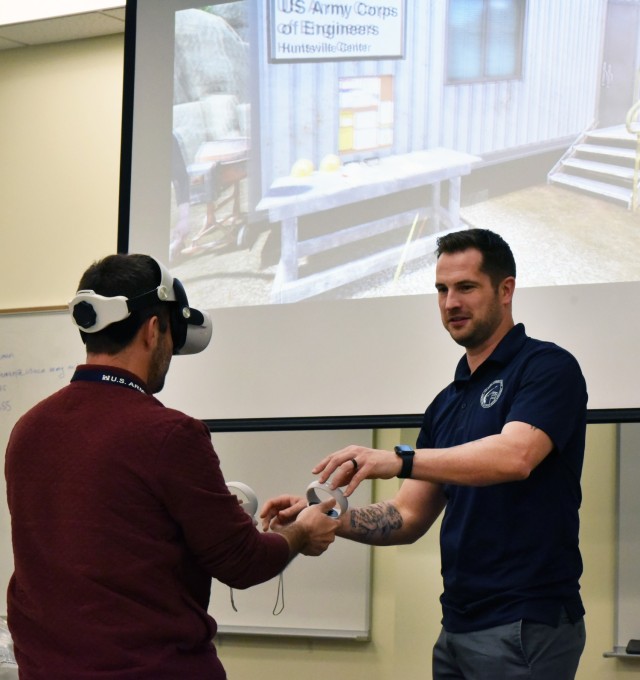 Kyle Shireman, Huntsville Center safety manager and visionary behind the Center’s new USACE Safety Trainer 360, explains how to use the virtual reality construction safety game’s headset and controllers to Shane Henry, audit technician, during a Occupational Safety and Health Administration 10-Hour Training Course held at the U.S. Army Engineering and Support Center, Huntsville.