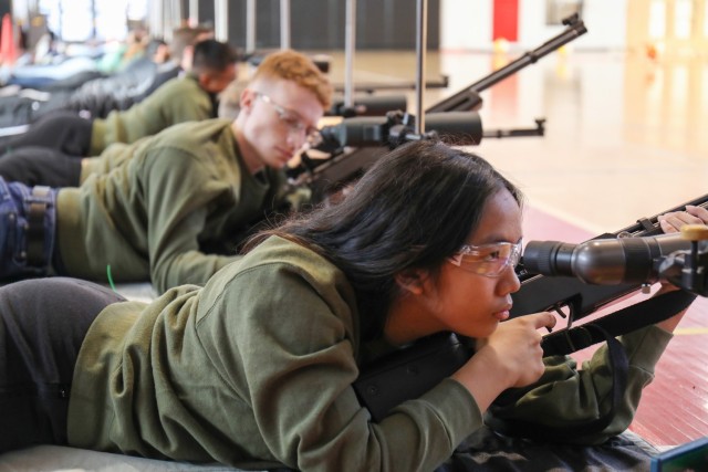 Kyyuen 	Chua, a cadet from Kubasaki High School, uses a monocular to see her shots before she reloads during a marksmanship match inside Zama Middle High School&#39;s gym at Camp Zama, Japan, Jan. 20, 2023. More than 70 cadets from all eight...