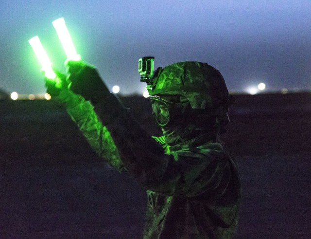 Sgt. 1st Class Joann Duclose, a senior human resources sergeant from the 642nd Aviation Support Battalion, flags in a UH-60 Black Hawk during night sling-load training with aviators from 3rd Battalion, 142nd Assault Helicopter Battalion, June 5, 2014, in Camp Buehring, Kuwait, during the battalion&#39;s 2014 deployment. Soldiers of the 642nd Aviation Support Battalion will deploy to the Middle East again later in 2023.  (N.Y. Army National Guard photo by Sgt. Harley Jelis/Released)