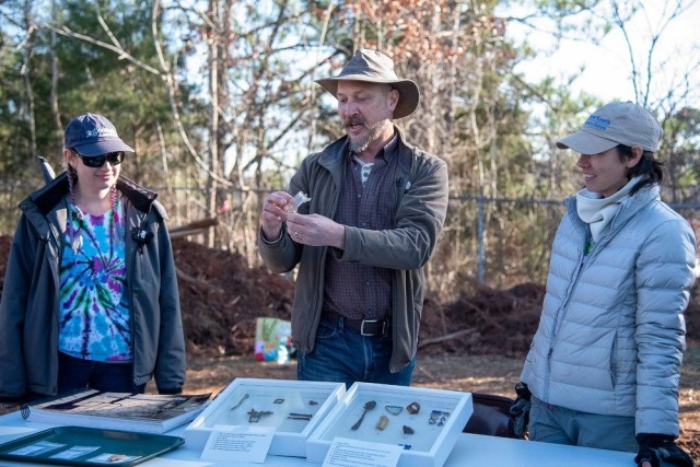 From left are Jenna Tran, historian with New South Associates Inc. and the excavation project; Ben Hoksbergen, Redstone Arsenal’s cultural resource manager; and Anne Dorland, of New South Associates, the principal investigator and archaeologist for the project. They display some of the artifacts that have been unearthed at a Redstone site. 
