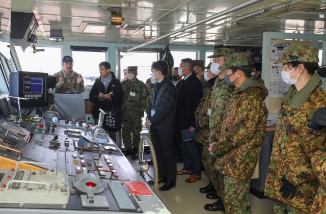 Chief Warrant Officer 2 Jason McElrath, left, vessel master of LCU Calaboza, briefs a group of Japan Ground Self-Defense Force leaders during a tour of the U.S. Army landing craft utility vessel at Yokohama North Dock, Japan, Jan. 25, 2023.