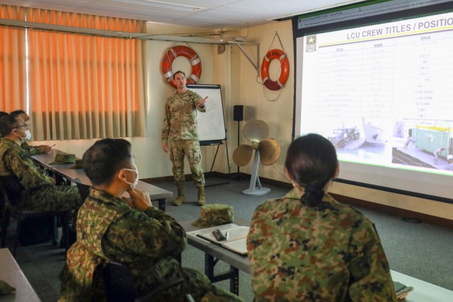 Chief Warrant Officer 3 Allan Pulsifer, liaison officer for the 10th Support Group&#39;s PULSE-W, conducts a capabilities brief to a group of Japan Ground Self-Defense Force leaders before they tour a U.S. Army landing craft utility vessel at Yokohama North Dock, Japan, Jan. 25, 2023. PULSE-W, or Pacific Utilities Logistic Support Enablers–Watercraft, is a rotation of Army vessels that supports various exercises and missions in the region. 