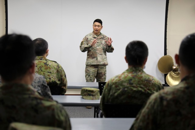 Lt. Col. Yong Choe, operations officer for the 10th Support Group, speaks to a group of Japan Ground Self-Defense Force leaders before they tour a U.S. Army landing craft utility vessel at Yokohama North Dock, Japan, Jan. 25, 2023.