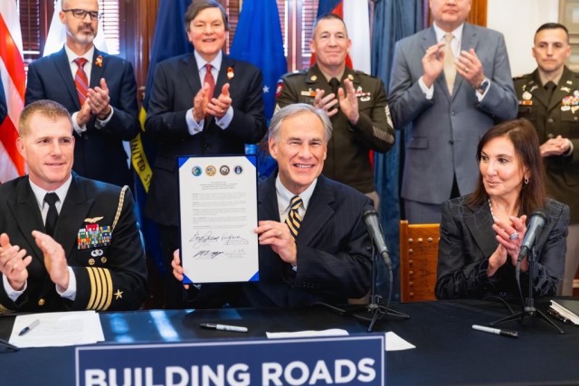 Texas Gov. Greg Abbott displays the newly signed intergovernmental support agreement (IGSA) between the state and the Army, Air Force, and Navy Jan. 25, 2023, joined by ASA (IE&E) Rachel Jacobson (right) and Sgt. Maj. Michael Perry, senior enlisted advisor to the DCS, G-9 (rear), and other leaders.